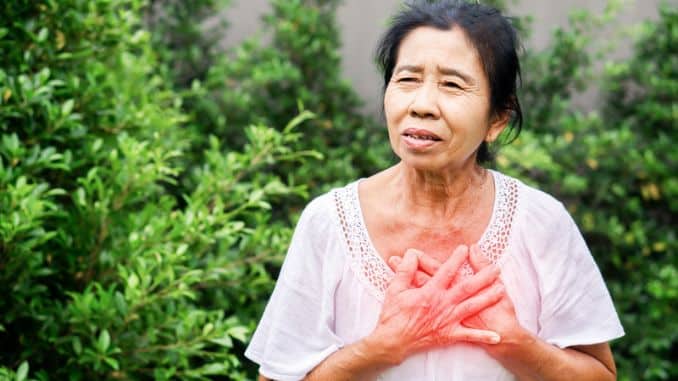 senior asian woman suffering heartburn